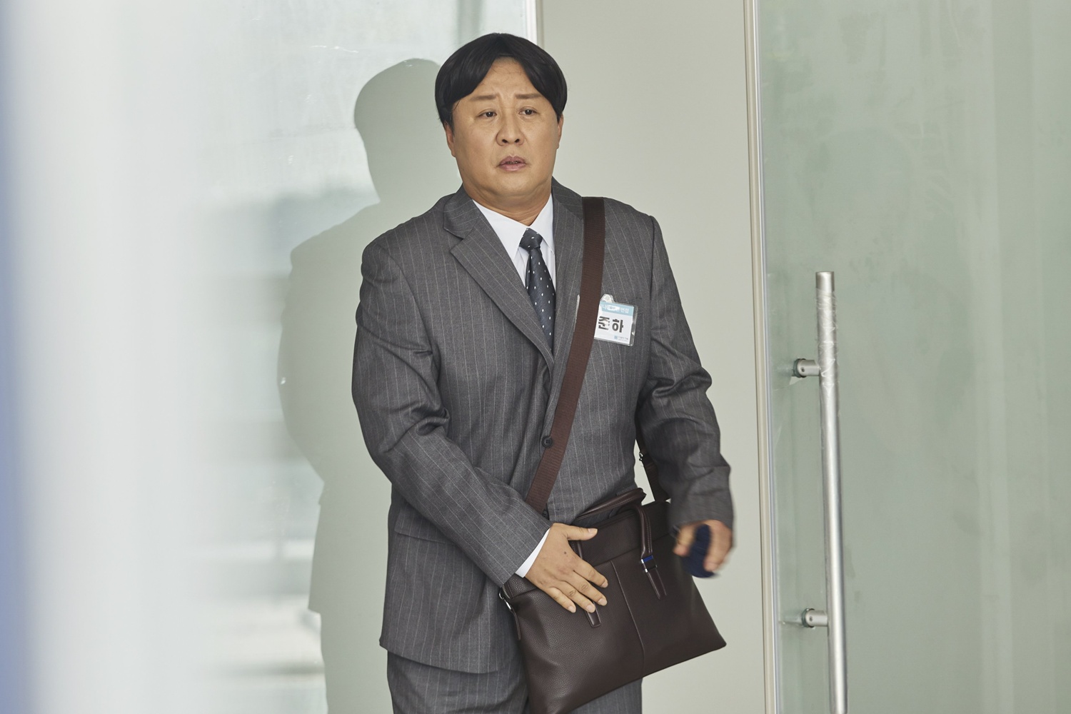 회색 정장을 입고 가방을 든 정준하의 직장인들3 공식 스틸